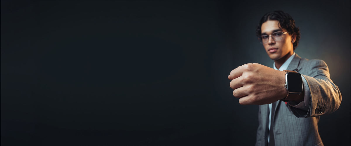 Man in pak met een smartwatch aan een leren bandje